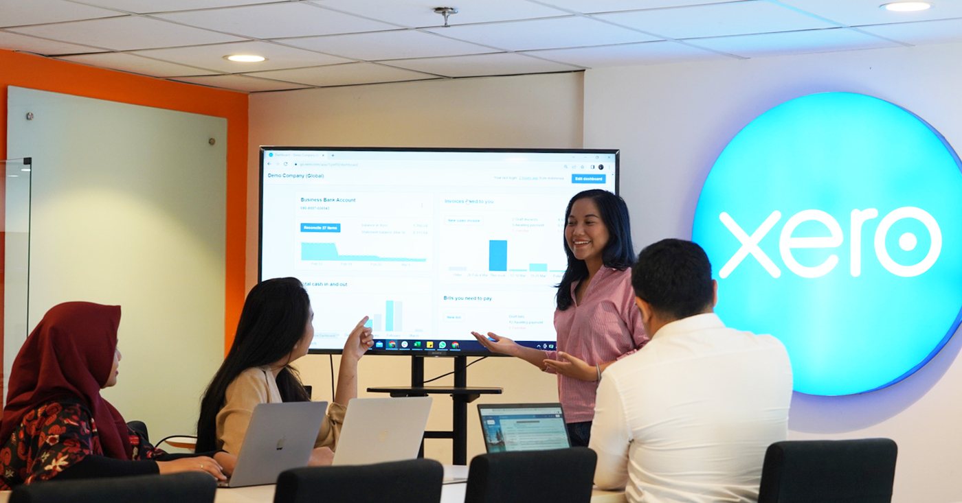 A Logiframe team member walking colleagues through a Xero dashboard on screen.