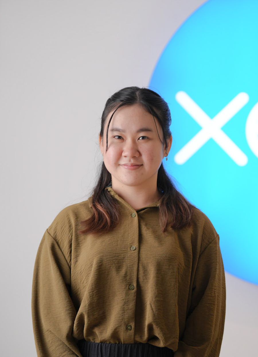 A Logiframe team member at the office, in front of the Xero sign.